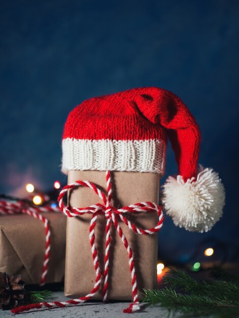 Cadeau de Noël en bonnet de Noel sur la table de vacances