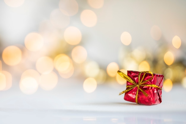 Cadeau de Noël boules rouges et argentées contre les lumières de bokeh fond de paillettes brillantes d'or avec espace de copie