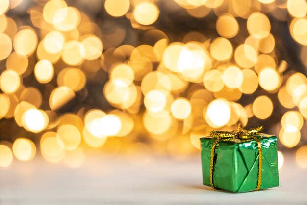 Cadeau de Noël boules rouges et argentées contre les lumières de bokeh fond de paillettes brillantes d'or avec espace de copie