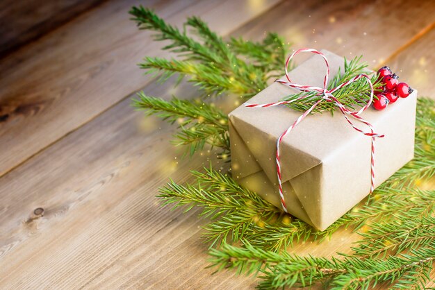 Cadeau de Noël et branches de sapin sur table en bois