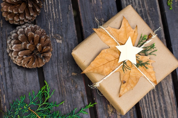 Cadeau de Noël avec décoration naturelle et pins coniques sur fond de bois