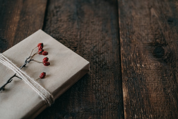 Cadeau de Noël écologique et durable zéro déchet emballé dans du papier kraft avec un décor de ficelle et de baies