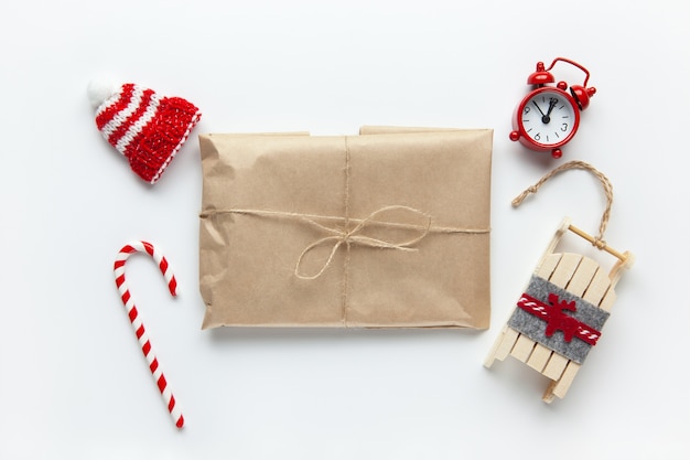 Cadeau de Noël emballé dans du papier kraft brun, attaché avec le fléau, avec des bonbons de canne,