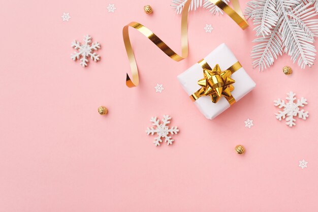 Cadeau De Noël Avec Des Flocons De Neige Et Décoration Sur Une Surface Pastel Rose