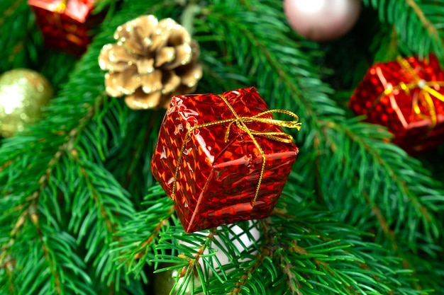 Photo cadeau de noël sur le fond de l'arbre de noël en gros plan