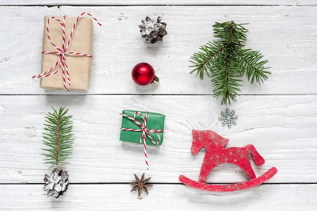 Cadeau de Noël, pommes de pin, branches de sapin, boule rouge et cheval jouet