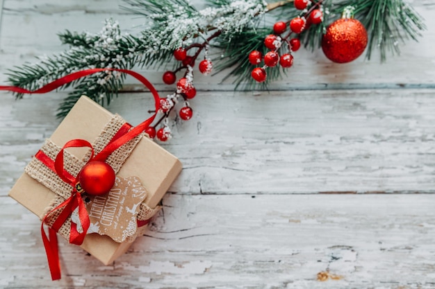 Cadeau de Noël avec un ruban rouge sur un fond en bois avec des flocons de neige