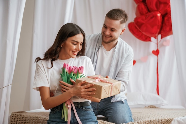 Cadeau pour la femme Décoration de fête Un jeune couple est ensemble à la maison