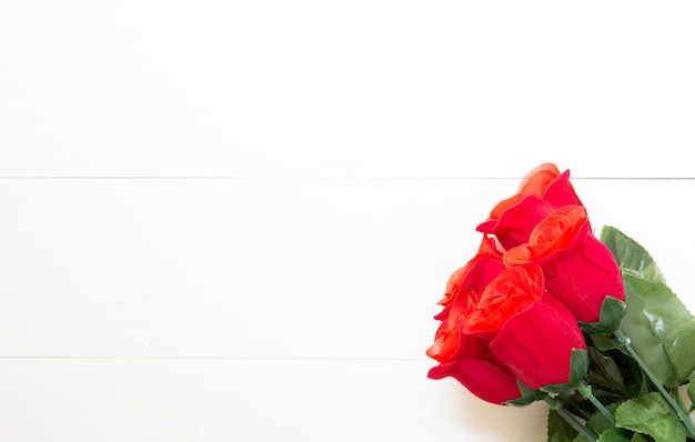 Cadeau présent avec une fleur rose rouge sur une table en bois