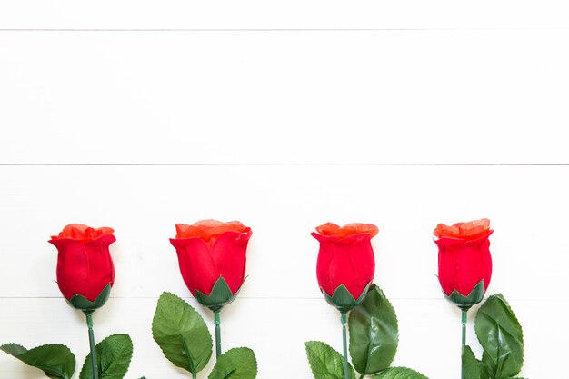 Cadeau présent avec une fleur rose rouge sur une table en bois