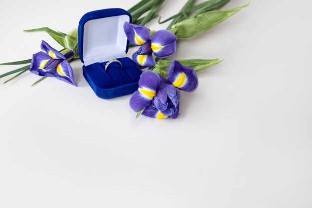 Cadeau Saint Valentin - bouquet de fleurs d'iris bleu et bague de fiançailles dans une boîte en velours bleu