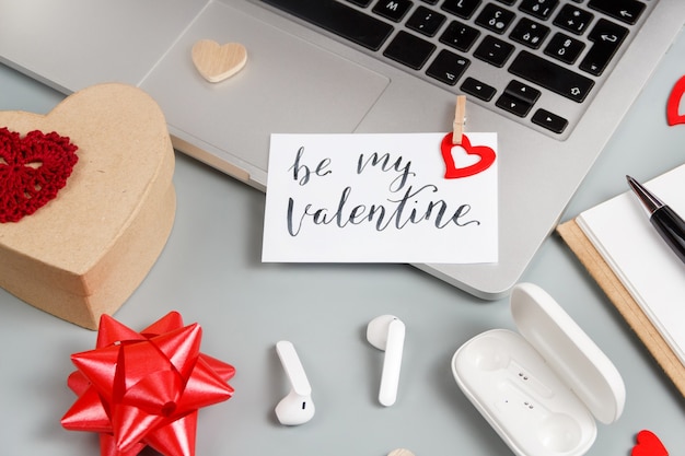 Cadeau de Saint Valentin et carte BE MY VALENTINE près de gadgets modernes sur table grise se bouchent. Concept de la Saint-Valentin