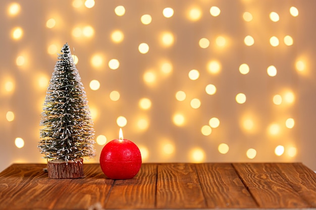 Cadeaux de bougies de bonhomme de neige de luge d'horloge d'arbre de Noël sur un fond en bois et un fond de lumières