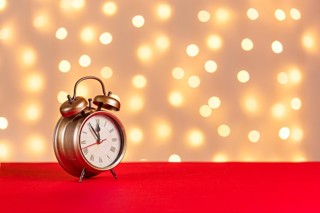 Cadeaux de bougies de bonhomme de neige de luge d'horloge d'arbre de Noël sur un fond rouge et un fond des lumières