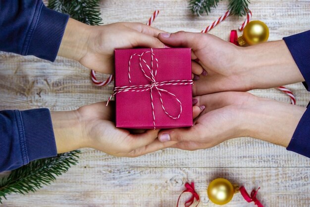 Cadeaux du nouvel an en mains sur un fond en bois. Mise au point sélective de Noël