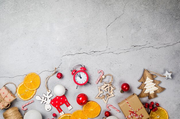 cadeaux emballés dans du papier kraft jouets en bois oranges sèches sur fond gris clair concept de Noël