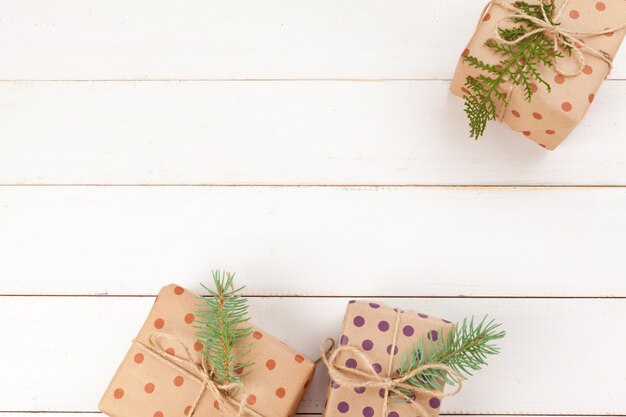 Cadeaux emballés avec du papier kraft sur une table en bois blanche