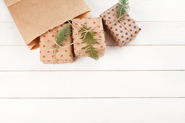 Cadeaux emballés avec du papier kraft sur une table en bois blanche