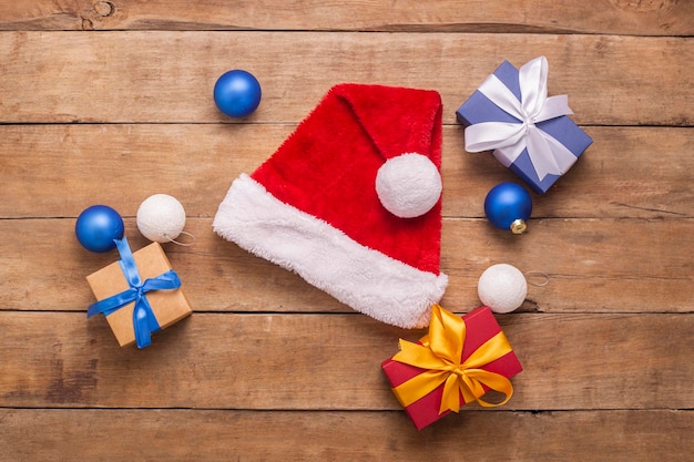 Cadeaux et jouets de chapeau de père noël sur un fond en bois vue de dessus mise à plat