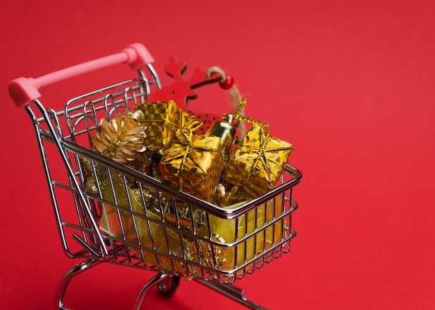 Cadeaux et jouets de Noël dans un chariot sur rouge