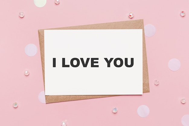 Cadeaux avec lettre de note sur fond rose isolé, concept d'amour et de Saint-Valentin avec texte je t'aime