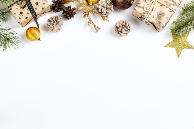 Cadeaux de Noël avec des boules, des pommes de pin et des branches d'épinette sur la vue de dessus de fond blanc. Mise à plat. Fond de vacances de Noël et du nouvel an. Concept de carte de voeux de Noël