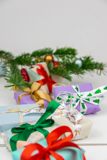 Cadeaux de Noël avec une branche d&#39;épinette et des décorations sur fond blanc.