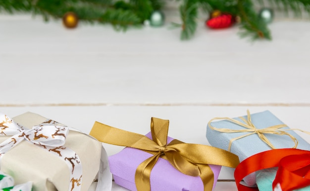 Cadeaux de Noël avec une branche d&#39;épinette et des décorations sur fond blanc.