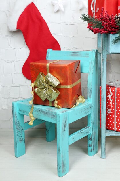 Cadeaux de Noël sur chaise bleue sur fond de mur de brique