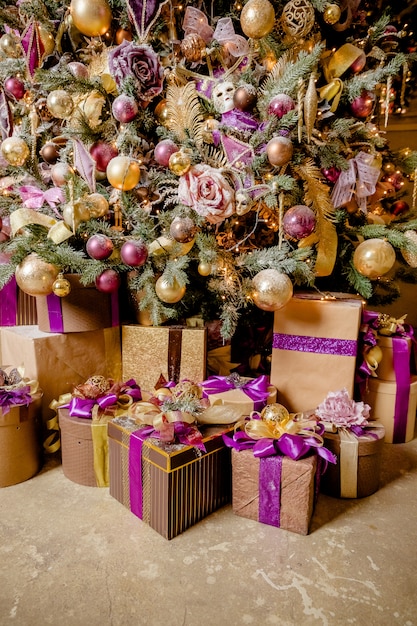 Cadeaux de Noël avec décoration violette et dorée, cadeaux. Décoration de Noël. coffrets cadeaux violets sous l'arbre de Noël