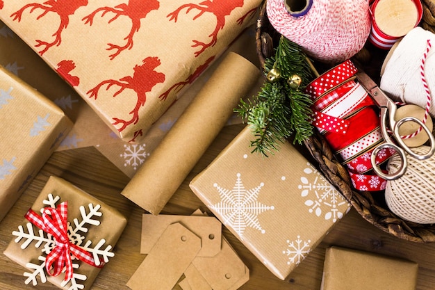 Cadeaux de Noël emballés dans du papier brun avec des rubans rouges.