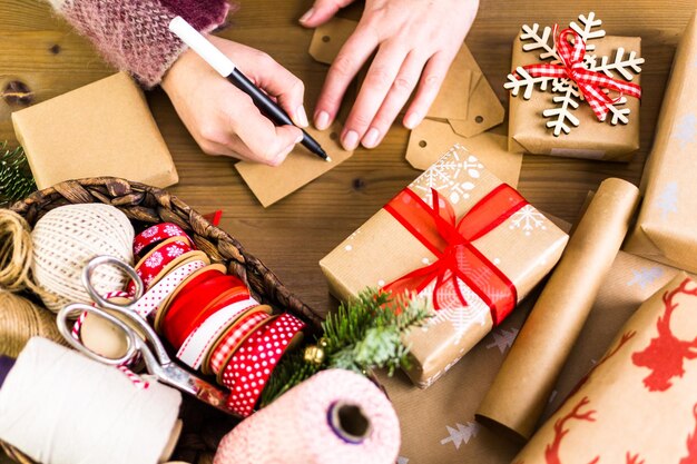 Cadeaux de Noël emballés dans du papier brun avec des rubans rouges.