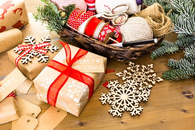 Cadeaux de Noël emballés dans du papier brun avec des rubans rouges.