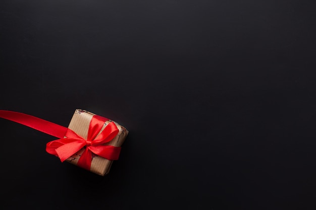 Cadeaux de Noël enveloppés dans un ruban rouge sur fond noir