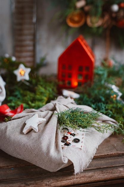 Cadeaux de Noël enveloppés de tissu furoshiki à la japonaise dans des branches de conifères de sapin et d'épinette. Préparation et conception des vacances du nouvel an. Style rustique fait à la main, idées bon marché
