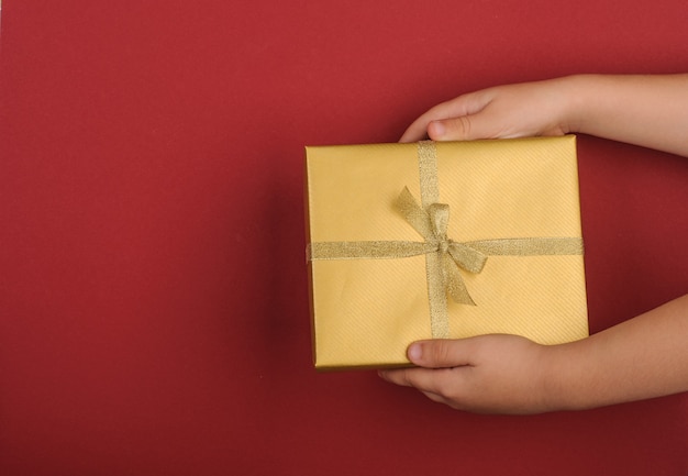 Photo cadeaux de noël en mains sur fond rouge