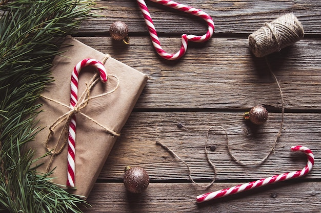 Cadeaux de Noël pour le nouvel an emballés dans du papier kraft près des branches d'épinette et des cônes sur fond de bois vue de dessus modèle copyspace