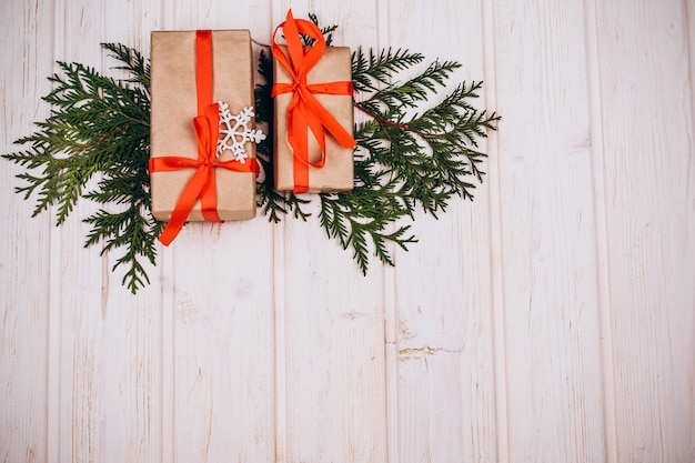 Les cadeaux de Noël se trouvent sur les branches de sapin sur la table en bois