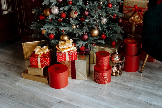 Cadeaux de Noël sous l'arbre dans un bel emballage rouge