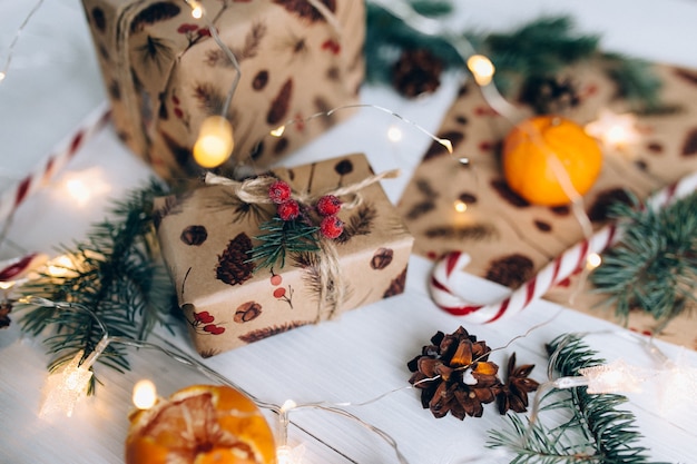 Cadeaux de Noël, sucette, mandarine sur table en bois blanc.