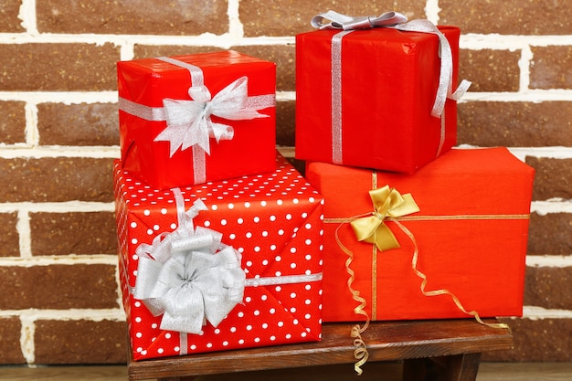 Cadeaux de Noël sur tabouret sur fond de mur de briques brunes