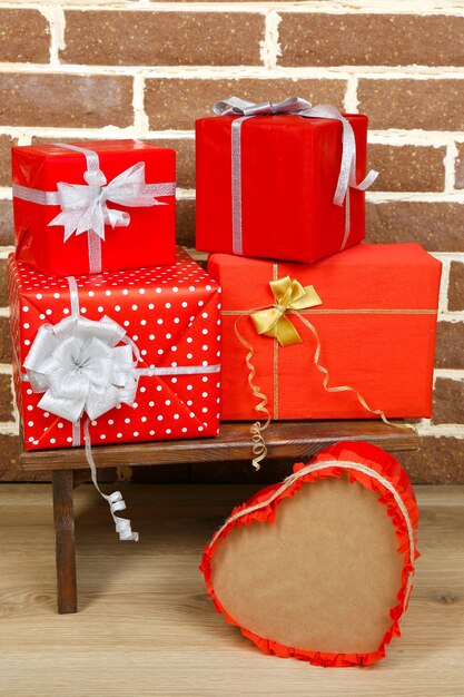 Cadeaux de Noël sur tabouret sur mur de briques brunes