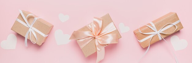 Cadeaux avec ruban wihte sur fond rose isolé