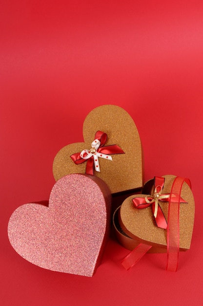 Cadeaux Saint Valentin scintillant rouge et or sur fond de papier rouge.