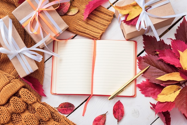 Cadeaux sur la table avec un cahier ouvert.