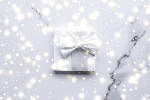 Photo cadeaux de vacances de luxe avec noeud en soie blanche et rubans sur fond de marbre surprise de noël