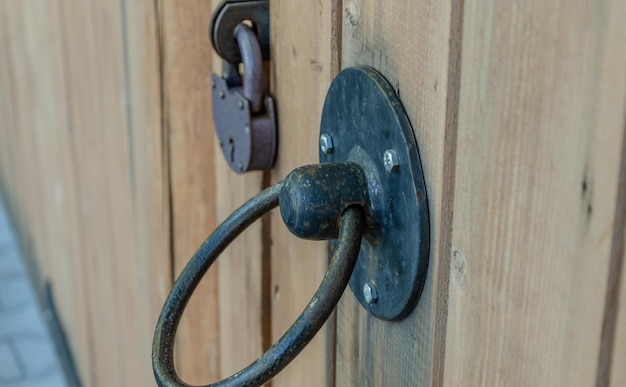 Un cadenas en fer sur une porte en bois.