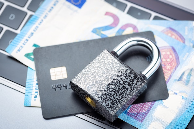 Photo cadenas fermé avec de l'argent et une carte de crédit sur le clavier d'un ordinateur portable