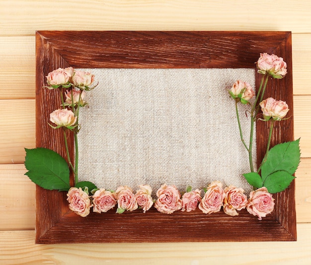 Photo cadre de belles fleurs sèches avec cadre sur fond de bois