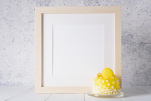 Cadre blanc avec un espace pour le texte et un petit gâteau jaune Fête d'anniversaire